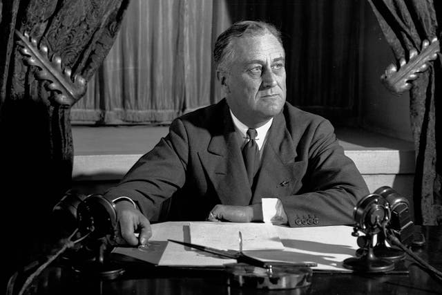 Franklin Roosevelt sitting at his desk, looking pensively to the side