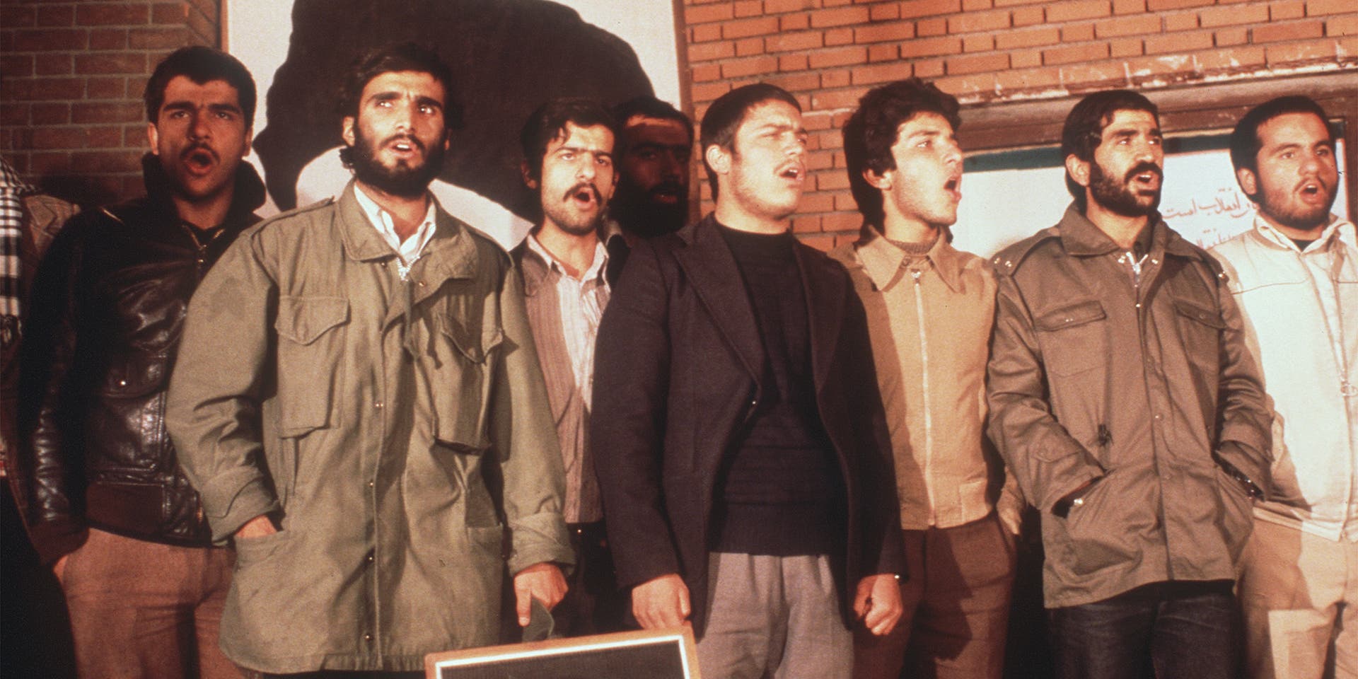The Iranian students, who have occupied the U.S EmTEHRAN, IRAN - NOVEMBER 19: The Iranian students, who have occupied the U.S Embassy in Tehran, are singing during the second released group of U.S. Embassy staffers hold a press conference 19 November 1979, two days after Ayatollah Khomeini ordered the release of all women and black U.S. hostages. Fanatical followers of the Ayatollah Khomeini stormed the United States Embassy, 04 November 1979 in Tehran, occupied the building and took nearly 100 embassy staff and Marines hostages. (Photo credit should read H. KOTILAINEN/AFP via Getty Images)