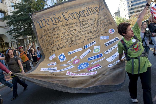 Protestors carry an altered US constitution dedicated to corporations at the 'Occupy Wall Street' protest and march down K Street in Washington, DC in 2011. Organizers protested 'corporate greed,' defense spending, banks and rising income inequality. (Credit: Linda Davidson/The Washington Post/Getty Images)