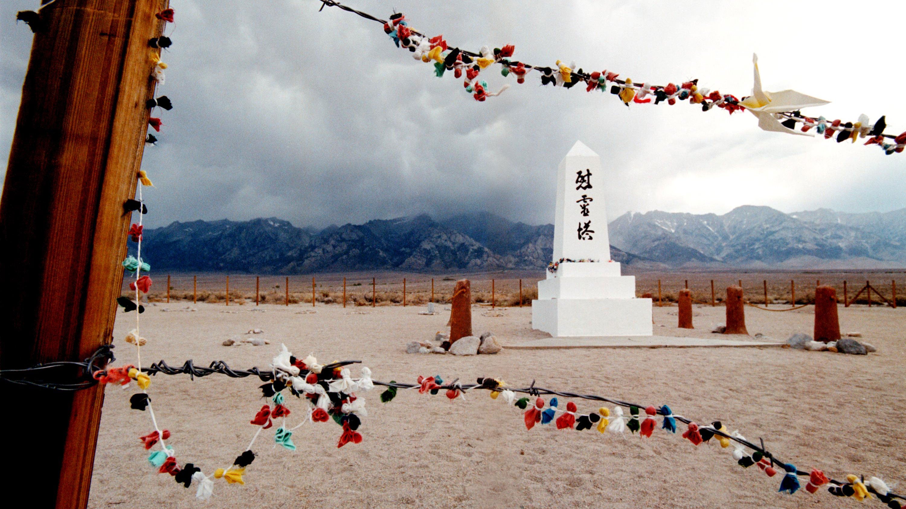 Offerings hanging on the barded wire fence surrounding the cemetery of the Manzanar War Relocation Center in 2000. Manzanarn served as an internment camp for 10,000 Japanese-American citizens and Japanese aliens during World War II after the bombing of Pearl Harbor. The National Park Service maintains Manzanar as a national historic site. (Credit: David McNew/Newsmakers/Getty Images)