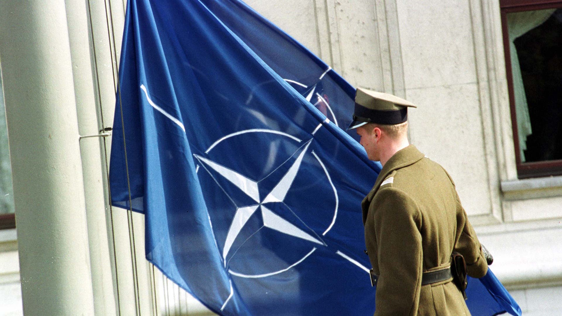 A Polish soldier lifts a Nato flag in front of the Polish Parliament building on March 16, 1999, as an official sign that Poland became a full member of the alliance.