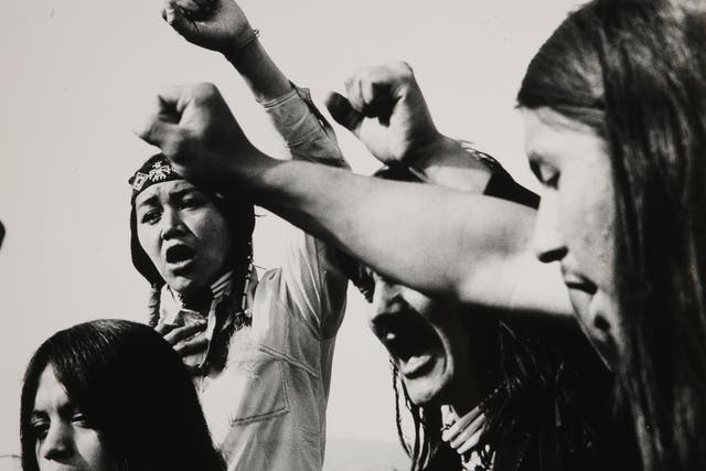 Circa 1975: During a protest gathering, some followers of AIM (American Indian Movement ) raise their fists to swear the Red Power oath.